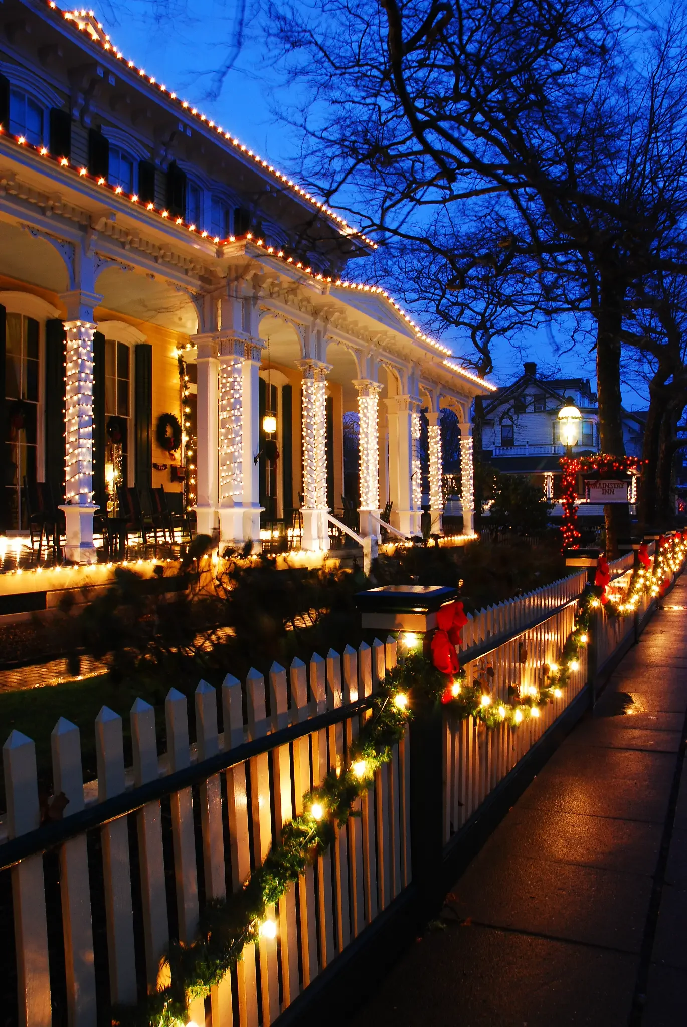Commercial building with warm white roofline lights, wrapped columns and garland shown as Christmas Lights inspiration